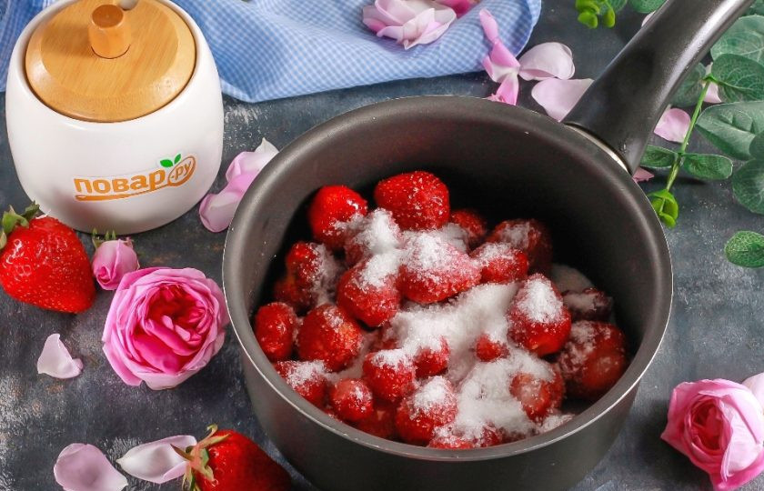 1. Этап. Варенье из клубники с лепестками роз: Выложите ягоды в казан, сотейник или в ковш с антипригарным дном, всыпьте туда же сахарный песок и влейте лимонный сок. Сок лимона будет препятствовать кристаллизации сахара и подчеркнет вкус варенья.