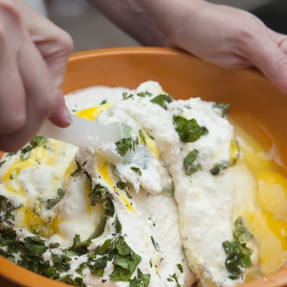 1. Этап. Равиоли с сыром: 7. В отдельную миску выложите сыр рикотта, четыре яйца, чайную ложку соли, черный перец. Базилик (или петрушку) промойте и мелко нарубите. Добавьте к сыру и яйцам. Смесь тщательно перемешайте до однородной массы.