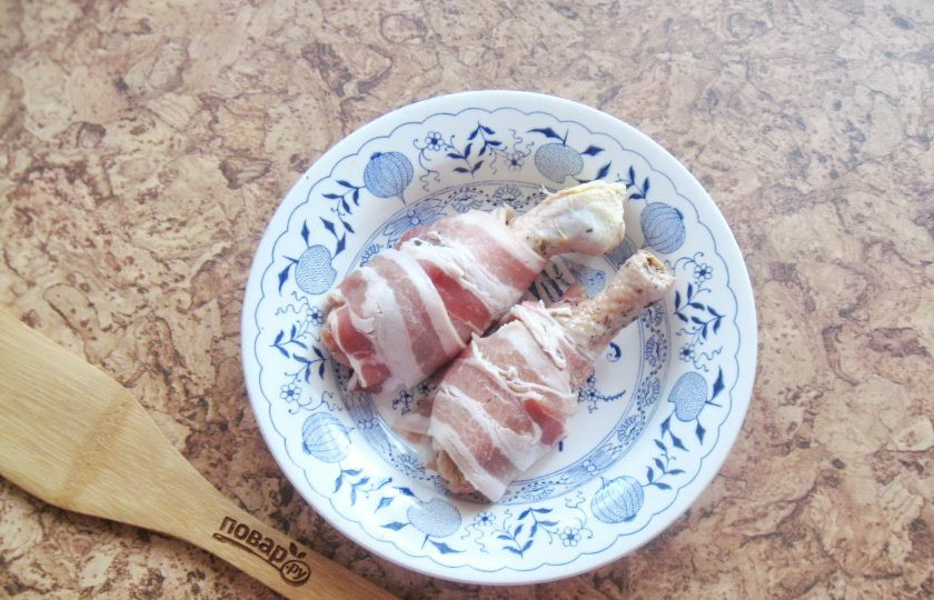 1. Этап. Куриные ножки в беконе в духовке: После каждую ножку обверните полосками бекона.