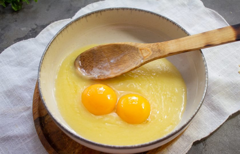 1. Этап. Суфле из яиц: Переложите заварное тесто в миску и добавьте яичные желтки, перемешайте.