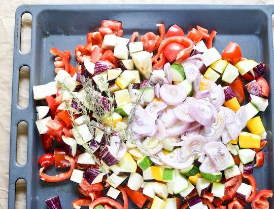 1. Этап. Экспресс-рататуй: 1. Нарежьте баклажаны, цуккини и томаты небольшими кубиками. Перец нарежьте ломтиками, луковицу - кольцами, чеснок измельчите. Выложите овощи на противень.