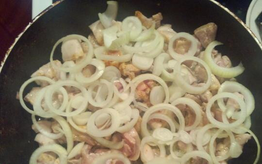 1. Этап. Тушеное мясо по-мексикански: Нарезаем кольцами лук, выкладываем поверх мяса. Готовим, не перемешивая, 5 минут.