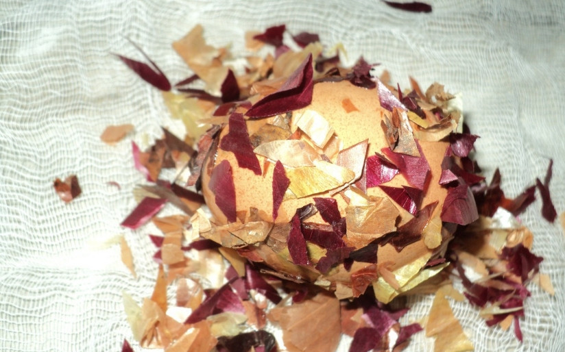 1. Этап. Мраморные яйца на Пасху: 1. Берем марлю, нарезаем ее на квадраты примерно в 15 см в обе стороны. Квадратов должно быть столько же, сколько и яиц. Теперь каждое яйцо намочим, затем обваляем в измельченной луковой шелухе и выложим на кусок марли.