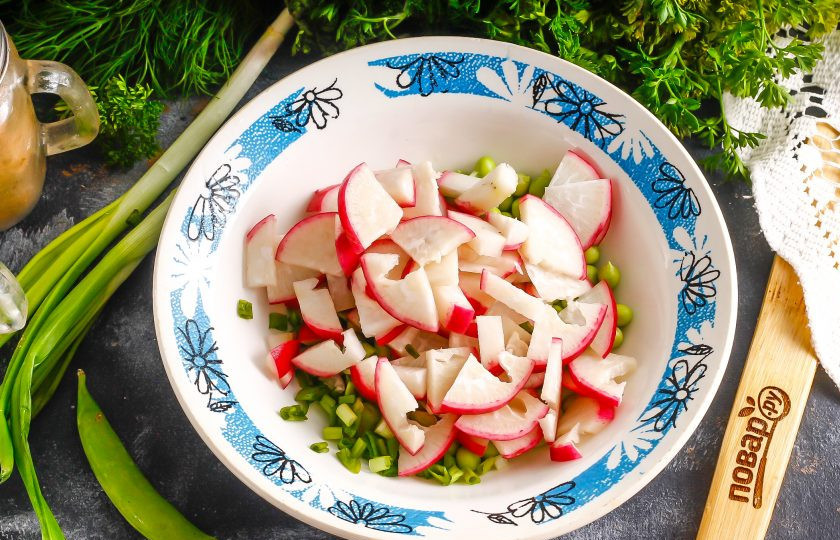 1. Этап. Салат с тыквенным маслом: Промойте редис, срежьте хвостики и нарежьте полукольцами, добавляя нарезку в емкость к горошку.