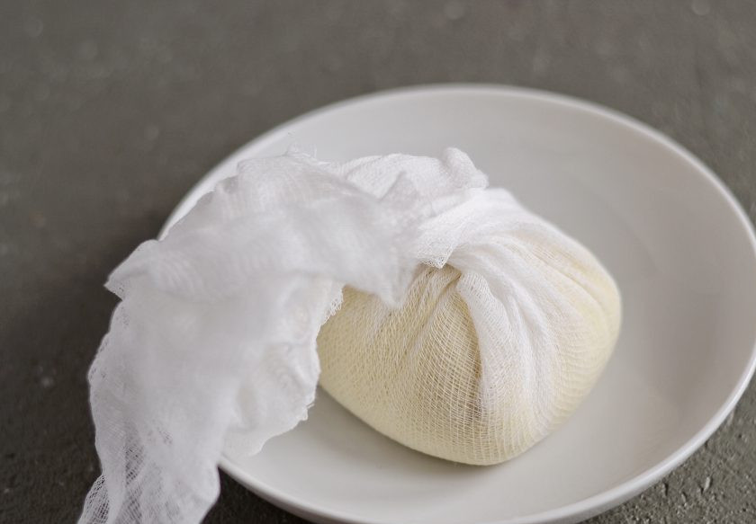 1. Этап. Миндальный сыр: Переложите массу в марлю, затяните и подвесьте на 8-12 часов, чтобы стекла лишняя жидкость.