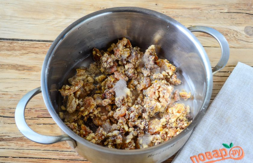 1. Этап. Варенье из кураги с грецким орехом: Теперь переложите массу в толстодонную кастрюльку, добавьте воду (не более 150 мл). Если хотите готовить варенье с сахаром, то сейчас самое время его добавить. Поставьте кастрюльку на медленный огонь и варите примерно 10 минут, пока вода не испарится, а сухофрукты не станут еще более мягкими.