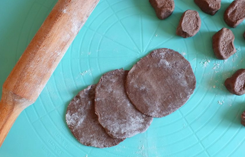 1. Этап. Шоколадные вареники с вишней: Подпылите рабочую поверхность мукой. Раскатайте каждую часть в тонкую лепешку.