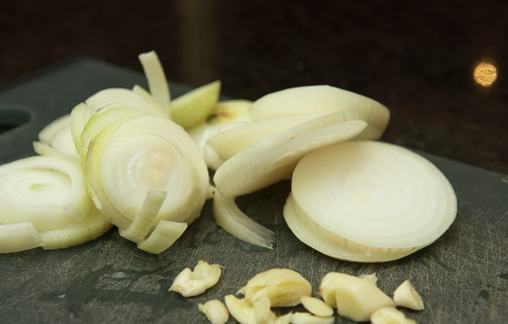 1. Этап. Говядина в красном вине: 2. Лук очистите и нарежьте кольцами. Чеснок очистите и измельчите ножом.