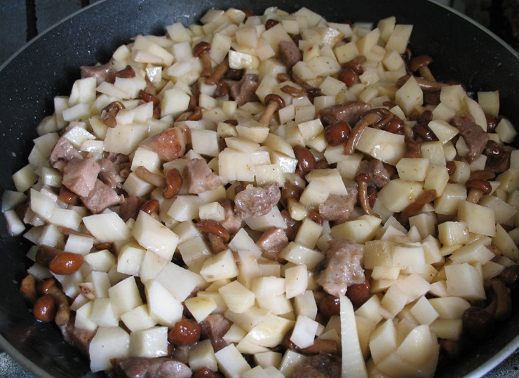 1. Этап. Картошка со свининой и грибами на сковороде: Выкладываем лук с картофелем в сковороду, солим и перчим по вкусу. Хорошо все перемегиваем и накрываем крышкой. Готовим, пока картофель не станет мягким.