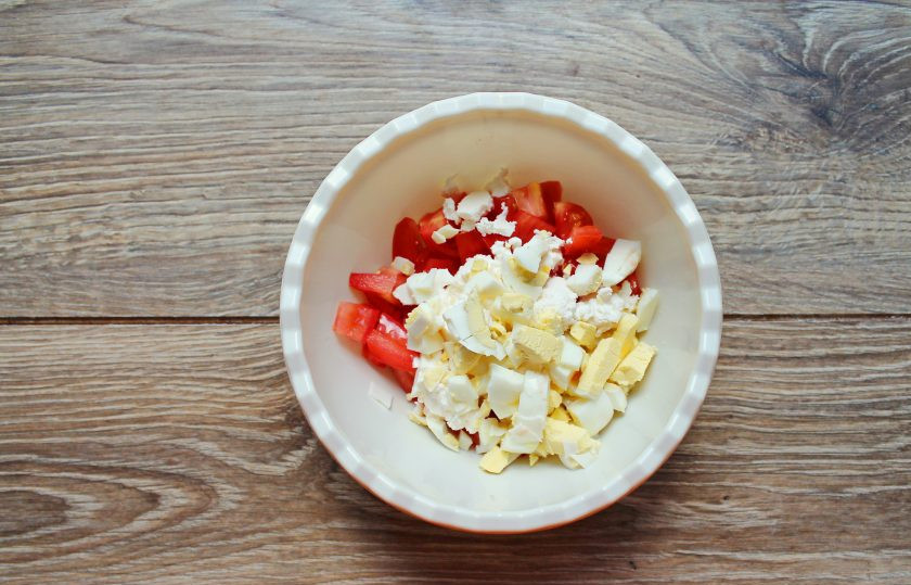 1. Этап. Салат с рикоттой и помидорами: Яйцо очистите и порежьте кубиком, добавьте в миску с рикоттой и помидорами.