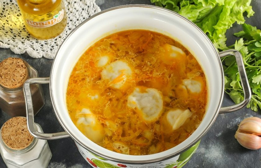 1. Этап. Сырный суп с пельменями: В кипящую воду выложите замороженные пельмени по одному и добавьте овощную зажарку. Отварите 10-12 минут.