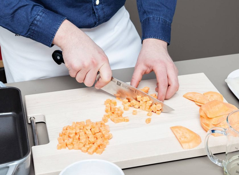 1. Этап. Запечённая треска с бататом: 1. Батат помойте, почистите и нашинкуйте мелкими кубиками. Смажьте форму для выпечки небольшим количеством масла, потом выложите туда картофель.