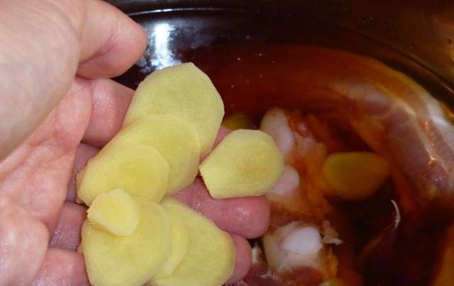 1. Этап. Свиные ребрышки в соевом соусе: Кусочек корня имбиря (примерно 4 см) чистим и нарезаем на пластинки, так же вкидываем в кастрюлю.