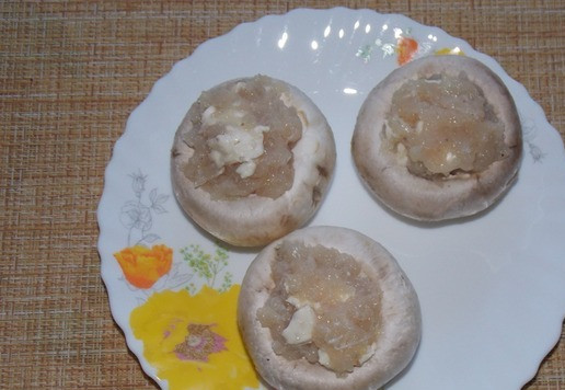 1. Этап. Фаршированные шампиньоны с фаршем и сыром: Выложить начинку в шляпки грибов.