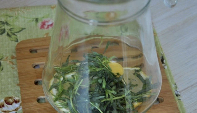 1. Этап. Тархун домашний: Веточки тархуна разминаем (удобно делать это в ступке), нам важно, чтобы он раскрыл свой восхитительный аромат. Лимон разрезаем на две половинки. Одну нарезаем небольшими дольками, а из второй просто выжимаем сок. Берем кувшин, в котором будем подавать лимонад. На дно выкладываем веточки тархуна с порезанным лимоном. Заливаем все это лимонным соком.
