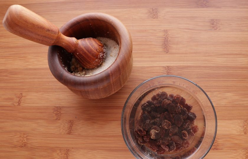 1. Этап. Рогалики с изюмом: Изюм залейте горячей водой на 20 минут, затем воду слейте и хорошо его обсушите. Грецкие орехи измельчите в ступке с 1 столовой ложкой сахара. Соедините орехи и изюм.