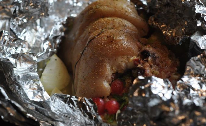 1. Этап. Свиная рулька в фольге: Далее мы аккуратно сворачиваем все рулетом и закрепляем его нитками, сверху делаем неглубокие надрезы. Затем посыпаем рульку специями, по бокам выкладываем нарезанный на крупные куски репчатый лук. Тщательно заворачиваем рульку в фольгу и запекаем ее 30 минут при температуре 180 градусов. По истечении времени фольгу следует отвернуть и еще минут на 10 поставить рульку в духовку, чтобы она подрумянилась.