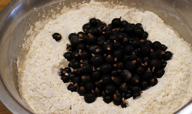 1. Этап. Кексы со смородиной на кефире: В миску к жидким ингредиентам добавляем муку с содой. Не размешивая, делаем небольшую дырочку, куда высыпаем смородину.