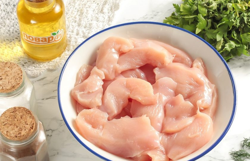 1. Этап. Наггетсы на сковороде: Куриное филе промойте, очистите от пленок и обсушите бумажными салфетками. Нарежьте небольшими длинными кусочками и выложите в глубокую емкость.