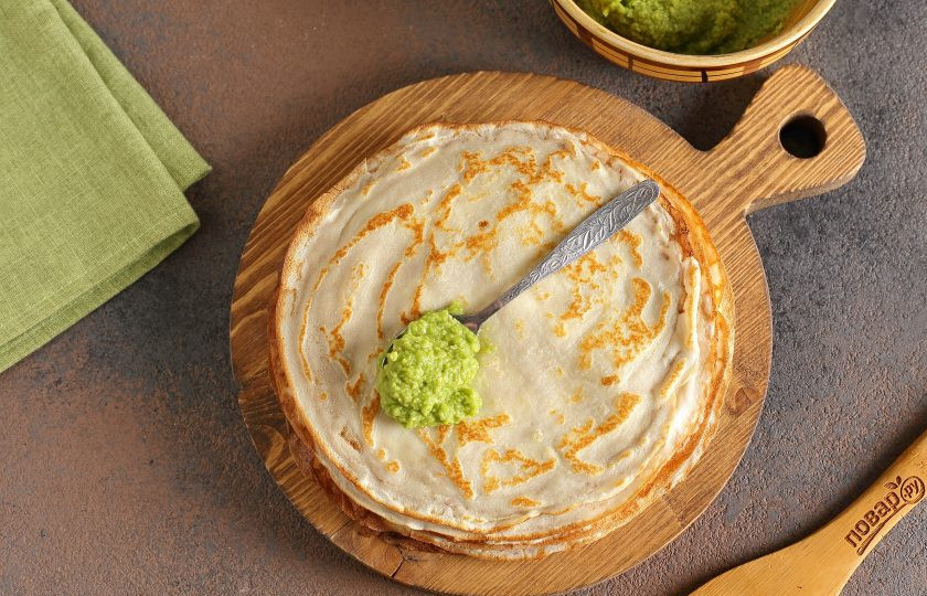 1. Этап. Блины с авокадо: Дайте блинчикам немного остыть, после чего смажьте их тонким слоем пасты из авокадо (около 1-1,5 ч.л. на каждый блин будет достаточно).