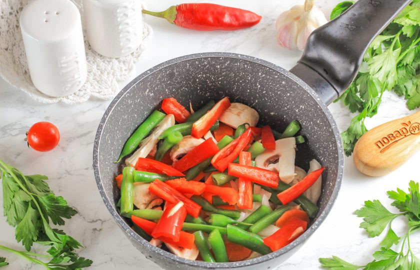 1. Этап. Японский суп с лососем: Со стручковой фасоли срежьте хвостики и нарежьте стручки на части. Очистите болгарский перец от семян и промойте. Нарежьте брусочками. Добавьте вместе с фасолью в емкость.