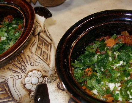 1. Этап. Човлент по-закарпатски: Теперь укладываем все подготовленные ингредиенты в горшочки. Первым слоем у нас будет перловка, затем фасоль, мясо, измельченный чеснок, овощи и зелень. Добавляем соль, черный перец и заливаем водой или бульоном так, чтобы ее уровень слегка покрывал верхний слой. Накрываем горшочки крышками и отправляем в нагретую до 160 градусов духовку примерно на 30-40 минут.