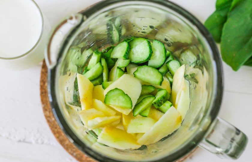 1. Этап. Смузи со щавелем: Промойте огурцы в воде, срежьте хвостики и нарежьте их полукольцами. Счистите с яблока кожуру, промойте и нарежьте мелкими ломтиками. Высыпьте обе нарезки в емкость блендера.