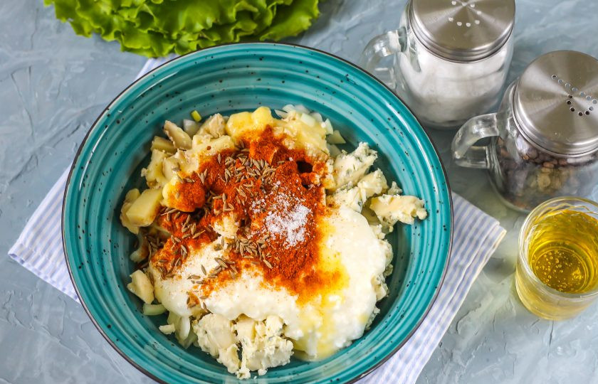 1. Этап. Обацда: Всыпьте молотую сладкую паприку и тмин. Цвет закуски будет полностью зависеть от количества добавленной паприки. Посолите и поперчите.