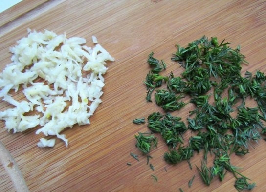 1. Этап. Фаршированные яйца со шпротами и красной икрой: 3. Чеснок чищу и измельчаю с помощью мелкой терки, укроп мою и нарезаю мелко.