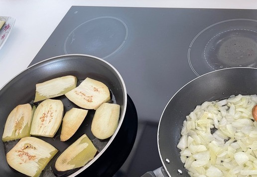 1. Этап. Рагу из баклажанов с зеленой чечевицей: Обжариваем пластины баклажанов с двух сторон на растительном масле. Обжариваем нарезанный лук. Если Вы хотите постное блюдо или не хотите тратить время на обжарку, этот шаг можно пропустить.