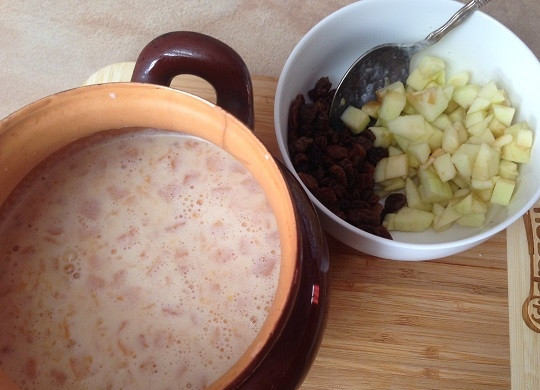 1. Этап. Запеченная пшенная каша с тыквой и яблоком: 7. Перекладываем пшено с тыквой в горшочек, добавляем яблоко и изюм, перемешаем.