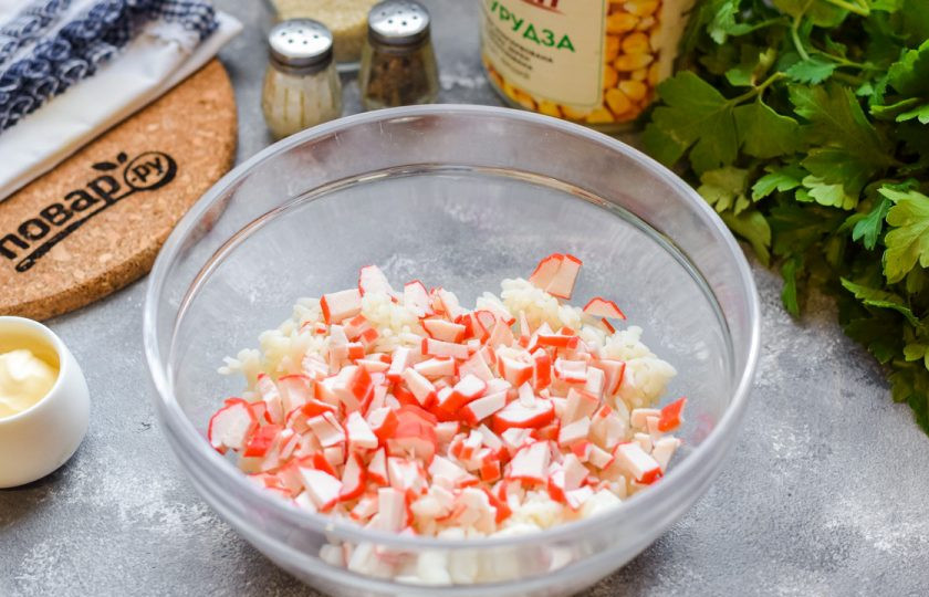 1. Этап. Крабовый салат с рисом и яблоком: Крабовые палочки нарежьте небольшими кусочками и добавьте в миску с рисом.