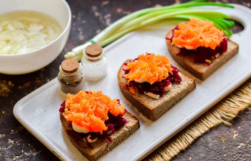 1. Этап. Бутерброды Сельдь под шубой: Следующий слой - натертая мелкой стружкой морковь. Выложите морковь поверх свеклы.