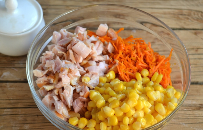 1. Этап. Салат с корейской морковкой и копченой курицей: Смещайте нарезанное куриное мясо, кукурузу и корейскую морковку.