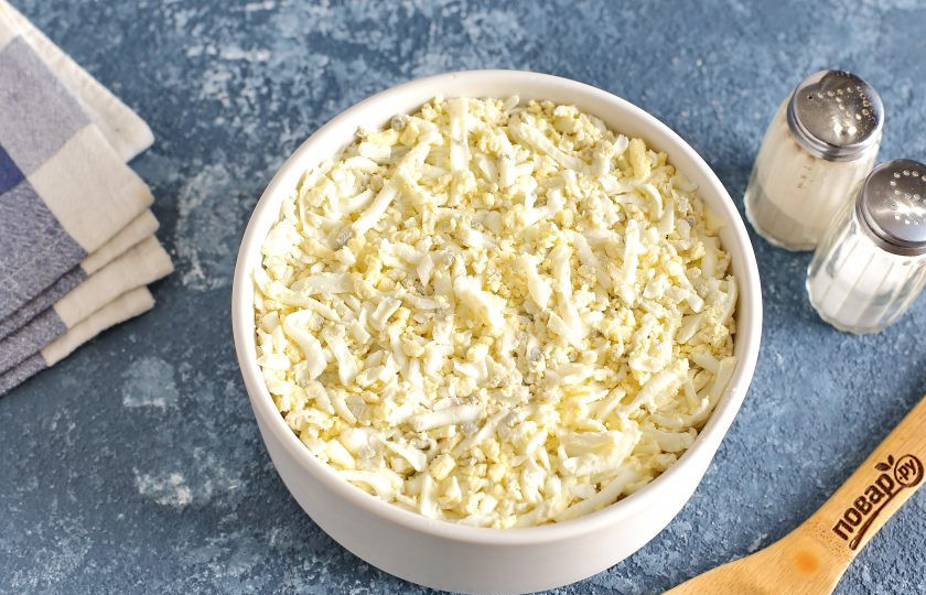 1. Этап. Слоеный салат с окорочком: Затем распределите тертые яйца.