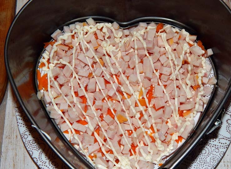 1. Этап. Салат с киви и ветчиной: Смажьте слой моркови майонезом. Ветчину куриную порежьте небольшими кубиками, выложите следующим слоем и тоже смажьте майонезом.