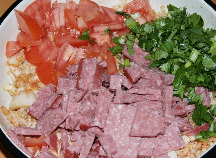 1. Этап. Салат пикантный с колбасой: Добавьте их к капусте, а также по вкусу можете еще зелень порубить в салат. Заправьте оливковым маслом.