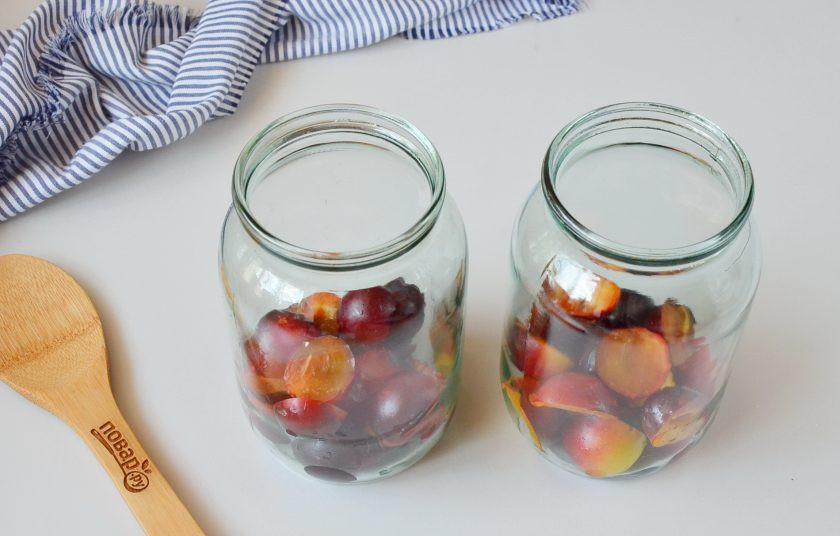 1. Этап. Сливовый компот на зиму: Сливы переберите, вымойте, порежьте половинками и удалите косточки. Выложите в стерильные банки.