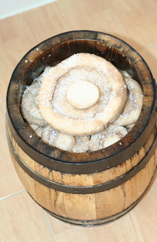 1. Этап. Грузди, соленые в бочке: 3. Выкладываем на дно бочонка чеснок, специи и добавляем промытые грибы, пересыпая их с солью.