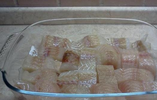 1. Этап. Запеченный минтай: Размораживаем филе минтая, промываем, высушиваем, нарезаем на кусочки и выкладываем в форму для выпекания, посолив и поперчив по вкусу.