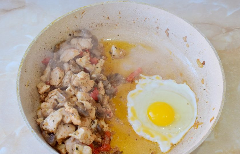 1. Этап. Тепаньяки с курицей: Содержимое сковороды сдвиньте и разбейте яйцо. Перемешайте его лопаткой. Почти сразу оно приготовится. Перемешайте все с яйцом. По вкусу добавьте соль и специи.