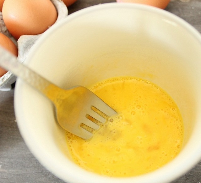 1. Этап. Яичный скрэмбл в кружке: Взбейте яйца вилкой. Добавьте соль и перец по вкусу, также можете внести натёртый сыр.