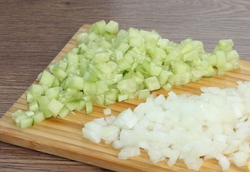 1. Этап. Слоеный салат с авокадо, тунцом, черри: 4. Очищаем лук от шелухи. Нарезаем огурец и лук маленькими кубиками.