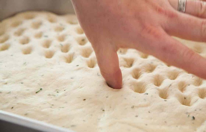 1. Этап. Итальянская фокачча с розмарином: 11. Пальцем сделайте в тесте глубокие отверстия, накройте его пленкой и оставьте снова на 2 часа.