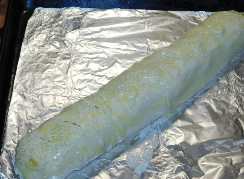 1. Этап. Рулет из слоеного теста с сыром: Сверните рулетом и подверните края, чтобы начинка не вытекала. Смажьте рулет желтком и посыпьте кунжутом. Сделайте несколько надрезов ножом. Поставьте в духовку, разогретую до 180 градусов, на 25-30 минут.