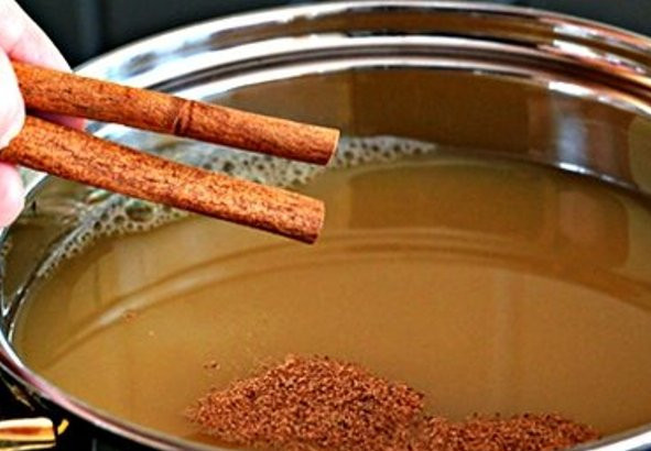 1. Этап. Пряный яблочный сидр: Добавьте к соку тертый орех, палочки корицы и ром. Перемешайте и варите на среднем огне минут 10. Периодически помешивайте.