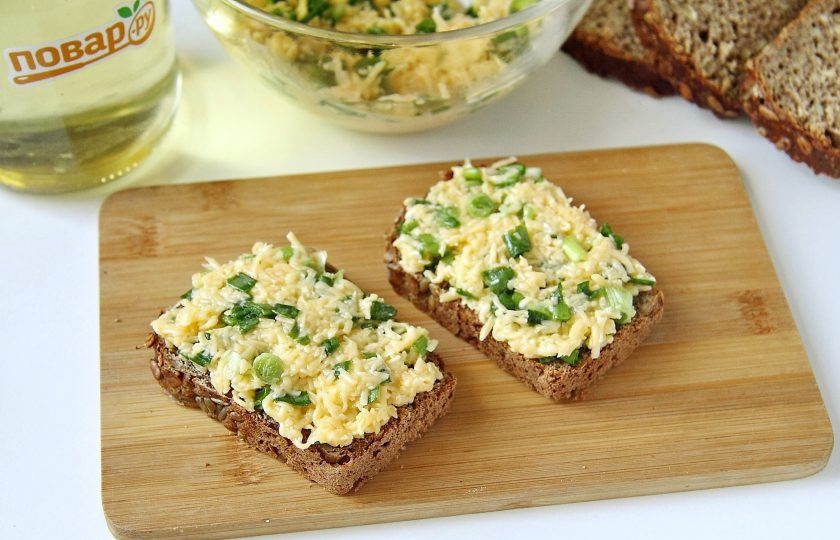 1. Этап. Бутерброды с луком и сыром: Хлеб или батон нарежьте тонкими ломтиками и намажьте сырной массой.