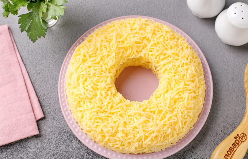 1. Этап. Салат с курицей и клюквой: И последним слоем, убрав стакан, выложите тёртый сыр.