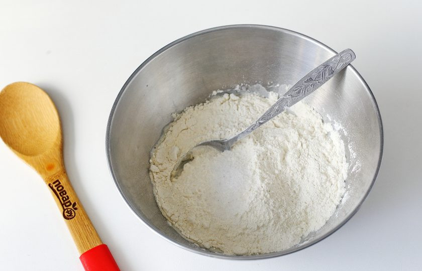 1. Этап. Пицца с тушенкой: В глубокой миске соедините теплую воду, сахар и дрожжи. Оставьте на 10-15 минут, затем добавьте муку и соль.