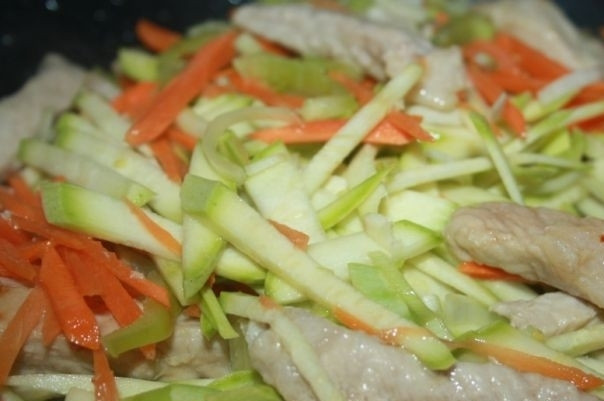 1. Этап. Китайская лапша со свининой: 2. Добавляем нарезанные тонкой соломкой овощи (лук, морковь и кабачок). Жарим, постоянно помешивая.